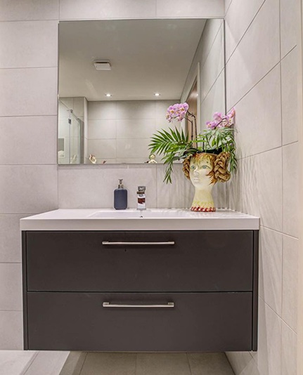 Stone vanity and warm grey cabinetry detail