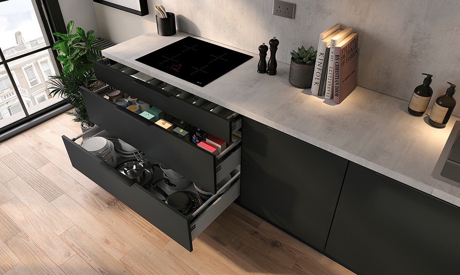 Open kitchen drawers with cookware and organisers beneath a porcelain worktop